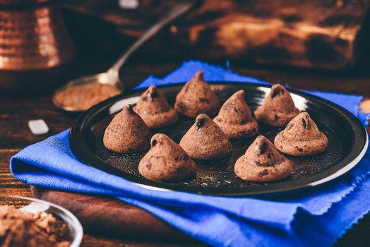 Homemade truffles with dark chocolate on metal tray