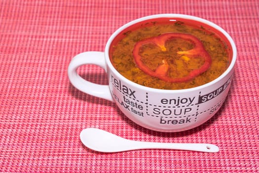 tomato soup in a mug on a red background top view. High quality photo