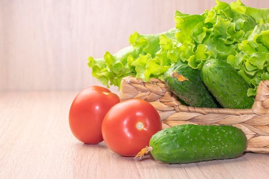 vegetables tomatoes cucumbers and cabbage in a basket on a wooden background. High quality photo