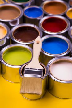 Metal tin cans with color paint and paintbrush