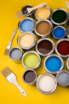 Metal tin cans with color paint and paintbrush