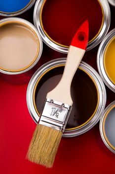 Tin cans with paint, brushes and bright palette of colors