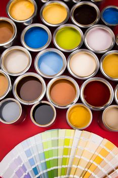 Tin cans with paint, brushes and bright palette of colors