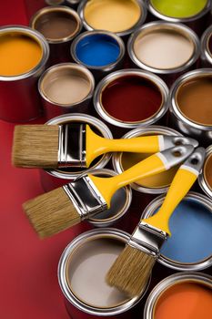 Tin cans with paint, brushes and bright palette of colors