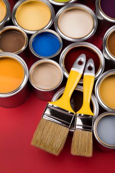 Tin cans with paint, brushes and bright palette of colors