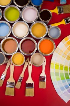 Tin cans with paint, brushes and bright palette of colors