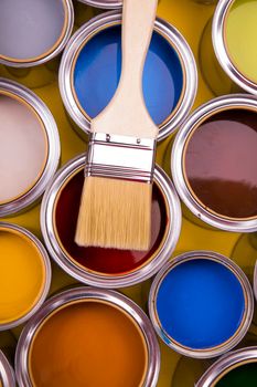 Tin cans with paint, brushes and bright palette of colors