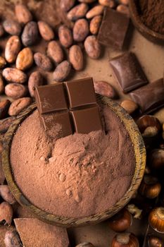 Dark homemade chocolate bars and cocoa pod on wooden