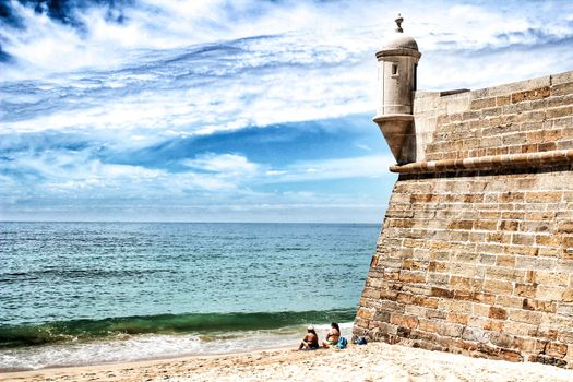 Sesimbra, Lisbon, Portugal- June 1, 2018: Views of the Sesimbra Beach and fortress under blue sky in spring in Portugal