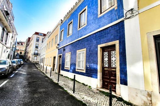 Colorful streets with majestic facades, windows and balconies of Lisbon city in Portugal on a sunny day