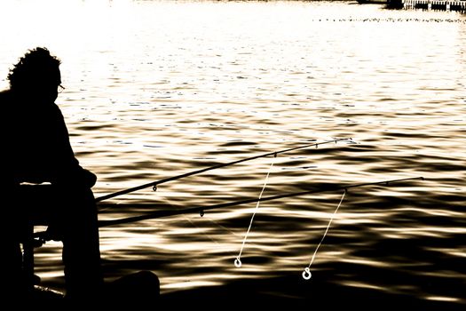 Man fishing silhouette in the port of Santa Pola in the afternoon
