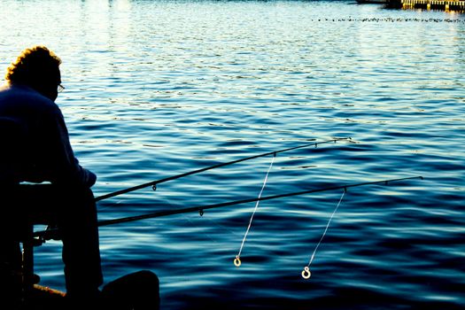 Man fishing silhouette in the port of Santa Pola in the afternoon