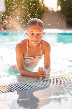 Happy beautiful girl having fun at the pool at the resort