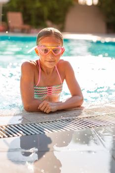 Happy beautiful girl having fun at the pool at the resort