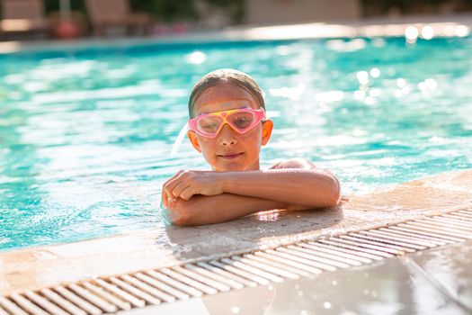 Happy beautiful girl having fun at the pool at the resort