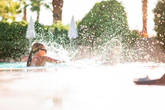 Happy beautiful girls having fun at the pool at the resort