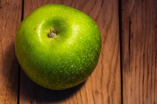 Tasty organic green juicy green apples on a rustic wooden background