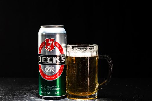 Can of Beck`s or Becks beer and beer glass on dark background. Illustrative editorial photo shot in Bucharest, Romania, 2021