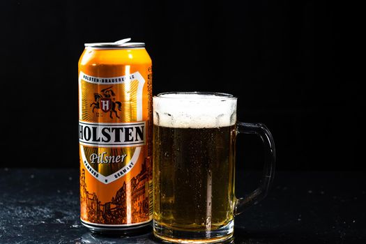 Can of Holsten beer and beer glass on dark background. Illustrative editorial photo shot in Bucharest, Romania, 2021