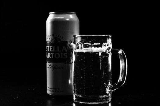 Can of Stella Artois beer and beer glass on dark background. Illustrative editorial photo shot in Bucharest, Romania, 2021