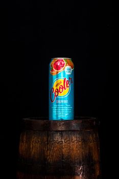 Can of Ursus Cooler beer on beer barrel with dark background. Illustrative editorial photo shot in Bucharest, Romania, 2021