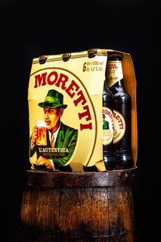 6 pack of Birra Moretti beer on wooden barrel with dark background. Illustrative editorial photo Bucharest, Romania, 2021