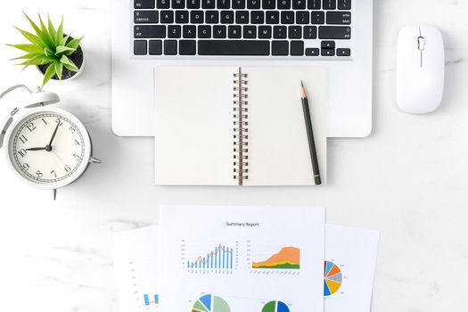 Top view of office table desk work concept with blank notebook, report, alarm clock on marble white background, concept of timing management and schedule planning.