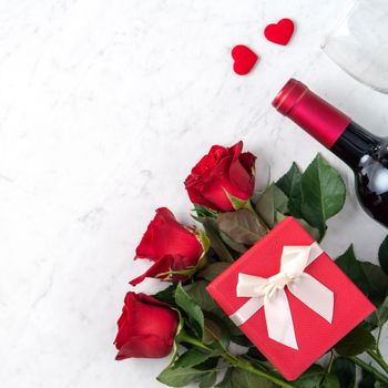 Top view of Valentine day gift with rose and wine, festive design concept for special holiday dating meal.