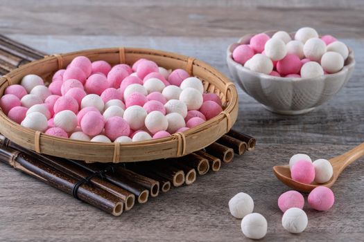 Raw red and white tangyuan glutinous rice dumpling balls on wooden table background for Winter solstice festival food.