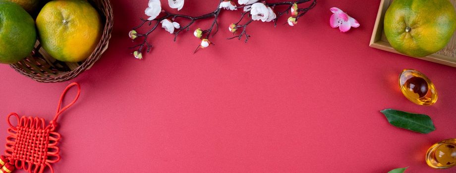 Top view of fresh ripe tangerine mandarin orange with fresh leaves on red table background for Chinese lunar new year fruit concept, the Chinese word means spring.