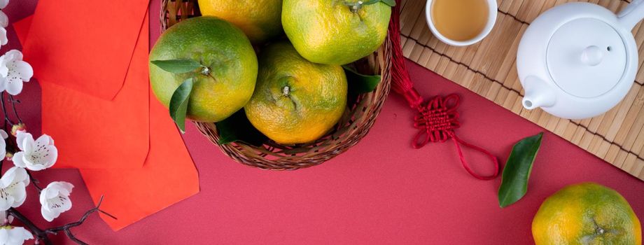 Top view of fresh ripe tangerine mandarin orange with fresh leaves on red table background for Chinese lunar new year fruit concept, the Chinese word means spring.