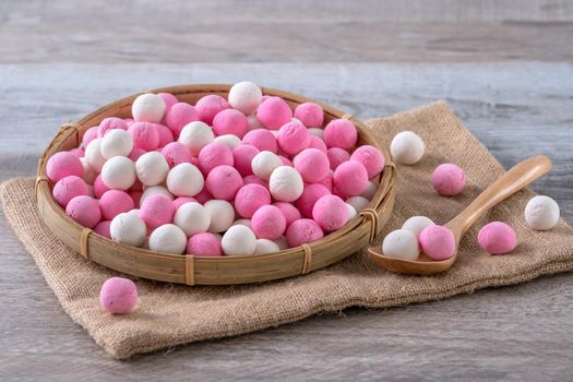 Raw red and white tangyuan glutinous rice dumpling balls on wooden table background for Winter solstice festival food.