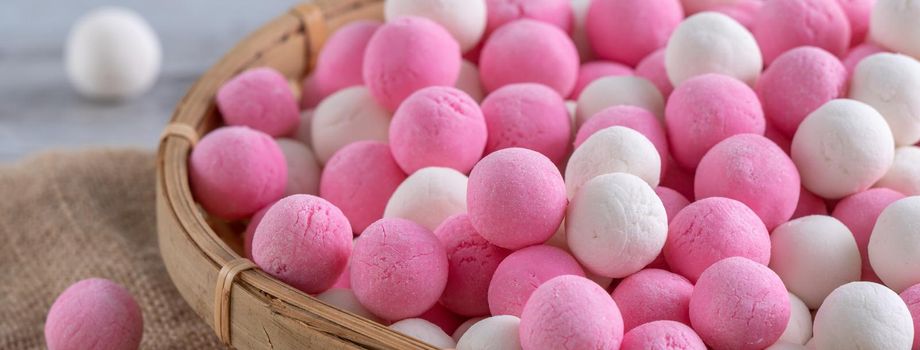 Raw red and white tangyuan glutinous rice dumpling balls on wooden table background for Winter solstice festival food.