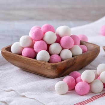 Raw red and white tangyuan glutinous rice dumpling balls on wooden table background for Winter solstice festival food.