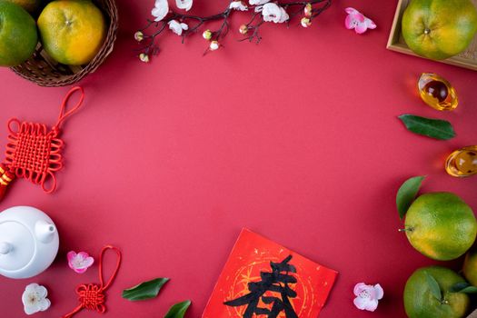 Top view of fresh ripe tangerine mandarin orange with fresh leaves on red table background for Chinese lunar new year fruit concept, the Chinese word means spring.