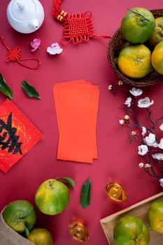 Top view of fresh ripe tangerine mandarin orange with fresh leaves on red table background for Chinese lunar new year fruit concept, the Chinese word means spring.