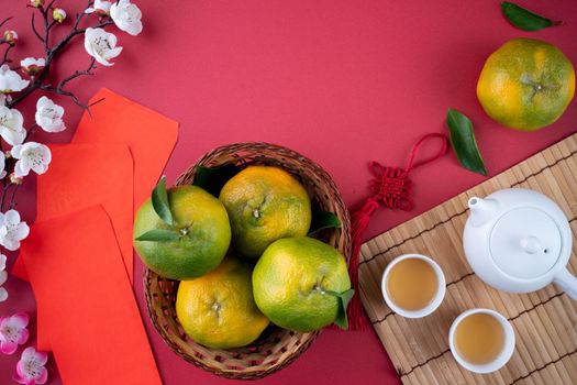 Top view of fresh ripe tangerine mandarin orange with fresh leaves on red table background for Chinese lunar new year fruit concept, the Chinese word means spring.