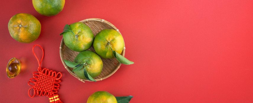 Top view of fresh ripe tangerine mandarin orange with fresh leaves on red table background for Chinese lunar new year fruit concept, the Chinese word means spring.
