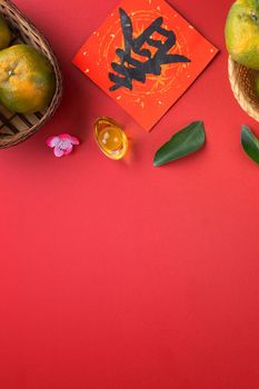 Top view of fresh ripe tangerine mandarin orange with fresh leaves on red table background for Chinese lunar new year fruit concept, the Chinese word means spring.