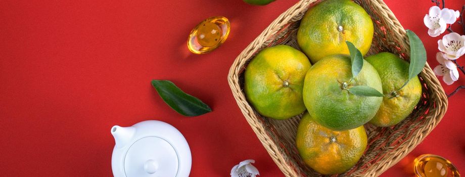 Top view of fresh ripe tangerine mandarin orange with fresh leaves on red table background for Chinese lunar new year fruit concept, the Chinese word means spring.