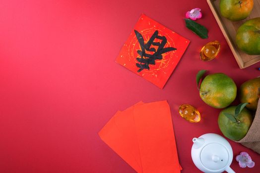 Top view of fresh ripe tangerine mandarin orange with fresh leaves on red table background for Chinese lunar new year fruit concept, the Chinese word means spring.