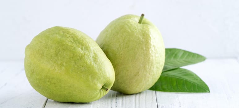 Close up of delicious beautiful Red guava with fresh green leaves isolated on white table background, studio table shot with copy space.