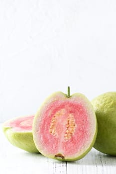 Close up of delicious beautiful Red guava with fresh green leaves isolated on white table background, studio table shot with copy space.