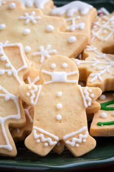 Close up of Christmas decorated sugar cookies in a plate on red table background.