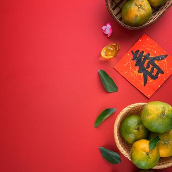Top view of fresh ripe tangerine mandarin orange with fresh leaves on red table background for Chinese lunar new year fruit concept, the Chinese word means spring.