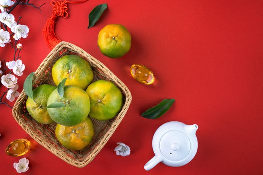 Top view of fresh ripe tangerine mandarin orange with fresh leaves on red table background for Chinese lunar new year fruit concept, the Chinese word means spring.