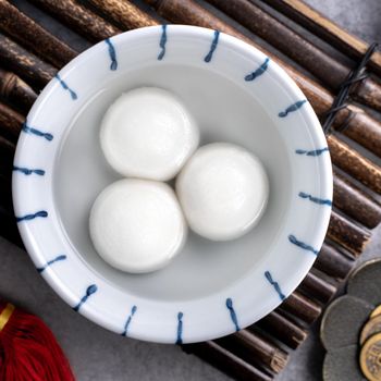Top view of big tangyuan yuanxiao (glutinous rice dumpling balls) for lunar new year festival food, words on the golden coin means the Dynasty name it made.