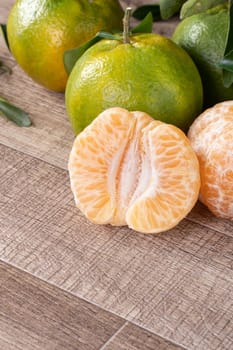 Fresh ripe tangerine mandarin orange in a box with fresh leaves on wooden table background harvest concept.
