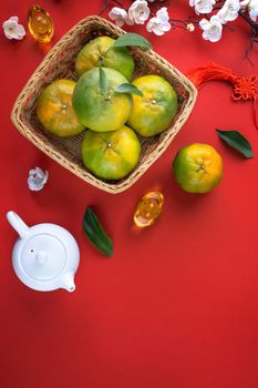 Top view of fresh ripe tangerine mandarin orange with fresh leaves on red table background for Chinese lunar new year fruit concept, the Chinese word means spring.