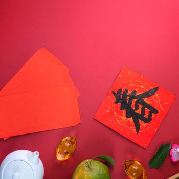 Top view of fresh ripe tangerine mandarin orange with fresh leaves on red table background for Chinese lunar new year fruit concept, the Chinese word means spring.